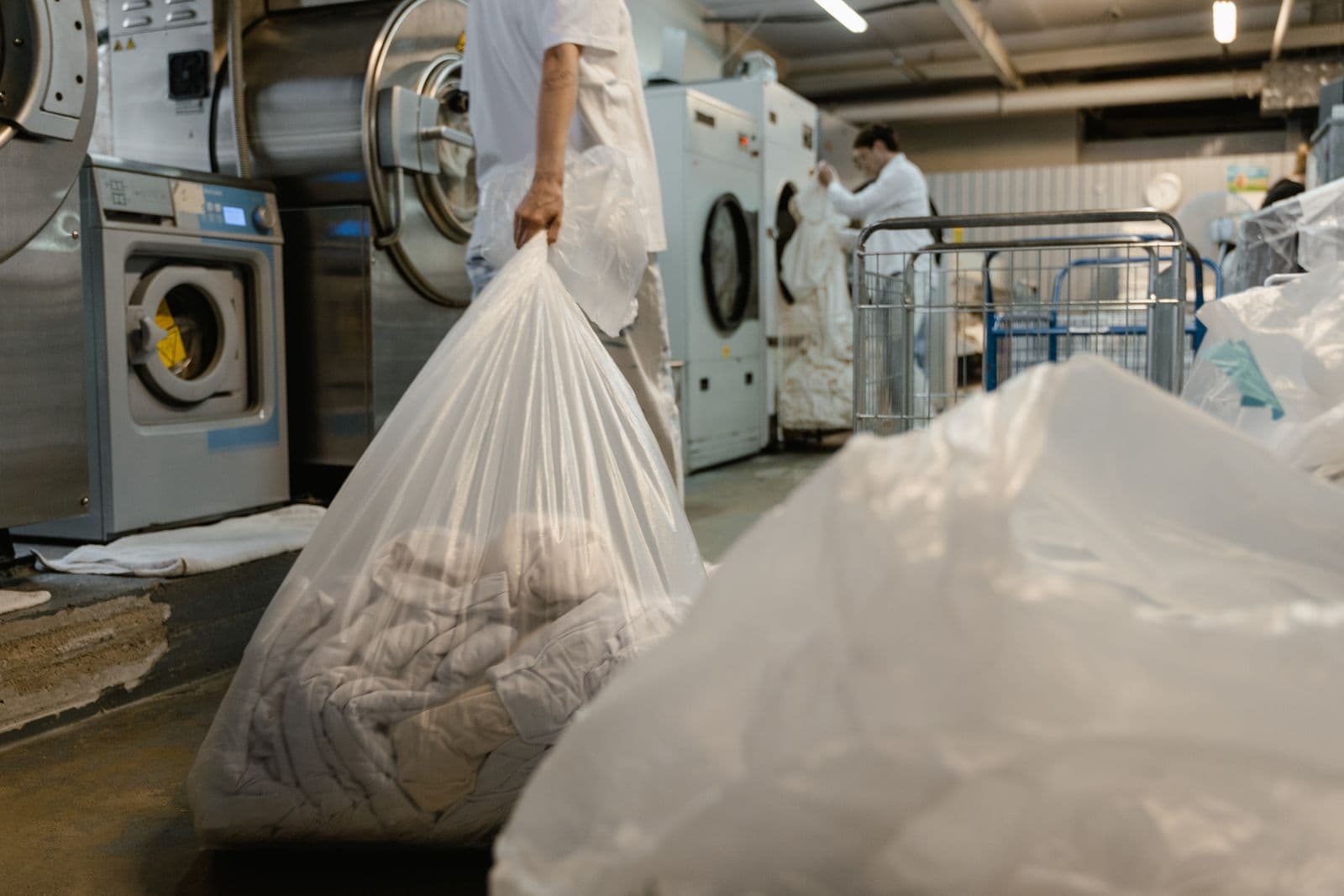 Laundry pickup and delivery worker carrying a laundry bag